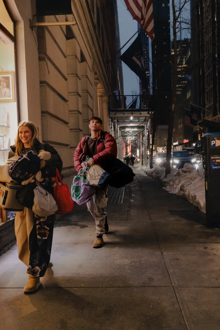 Man and woman rushing through New York with belongings