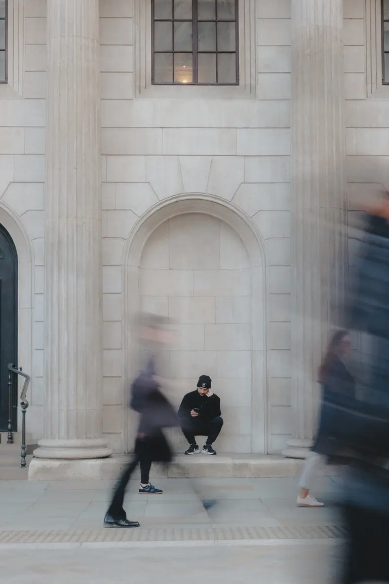 Man sitting down outside The Royal Exchange