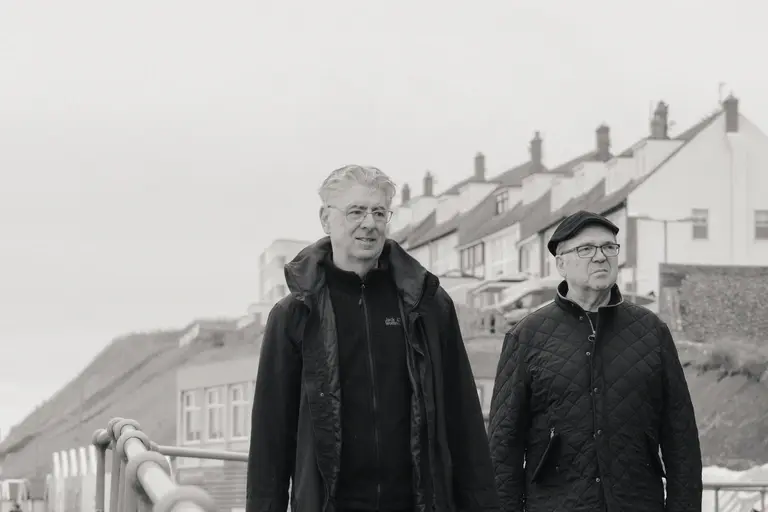 Friends walking along Sheringham coastline