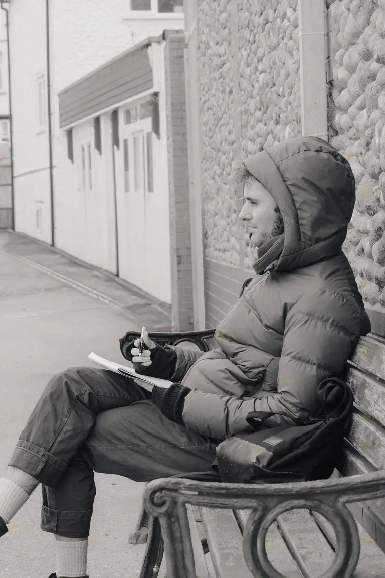 Man pondering and sketching at Sheringham seafront
