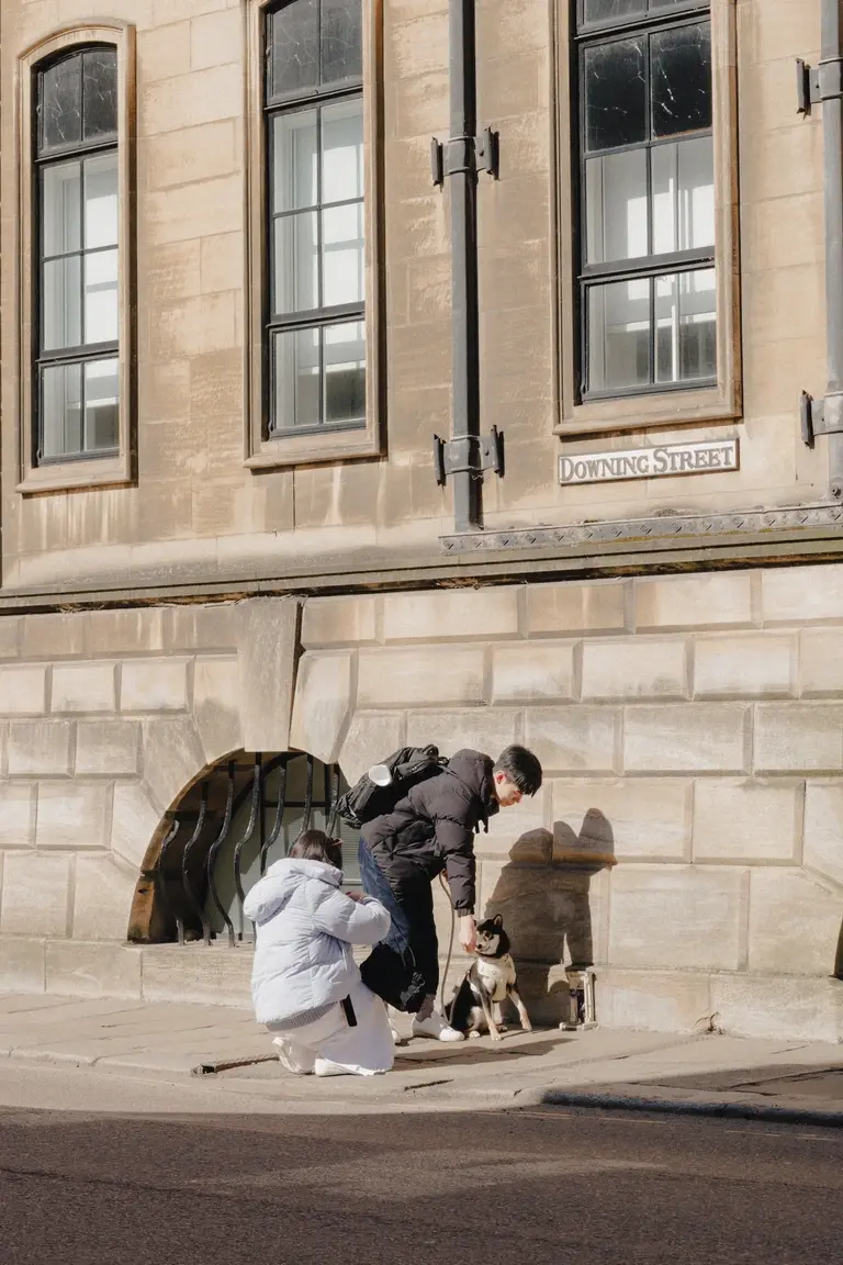 Couple photographing their dog against stone building