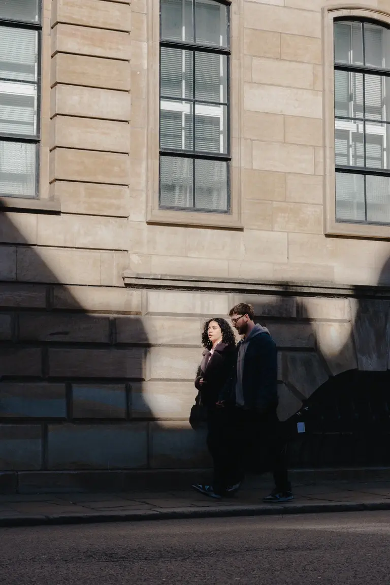 Couple walking through Cambridge city center at midday