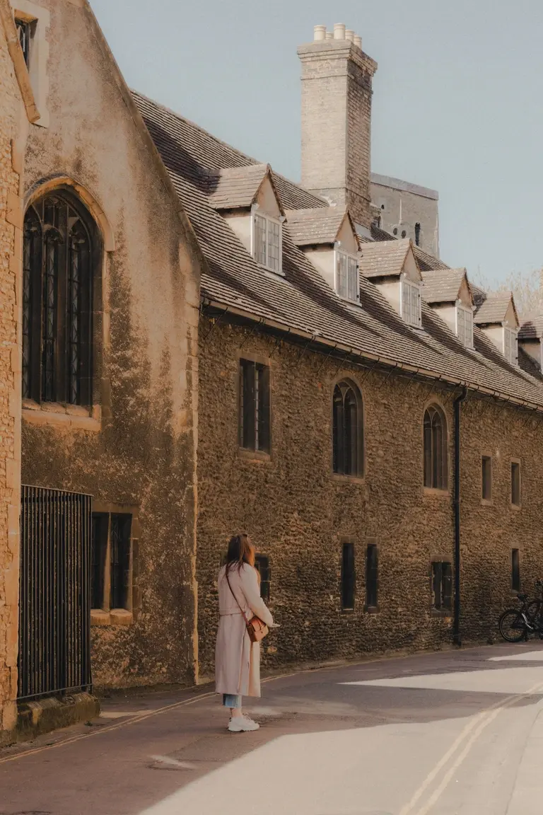 Woman looking at old cambridge building