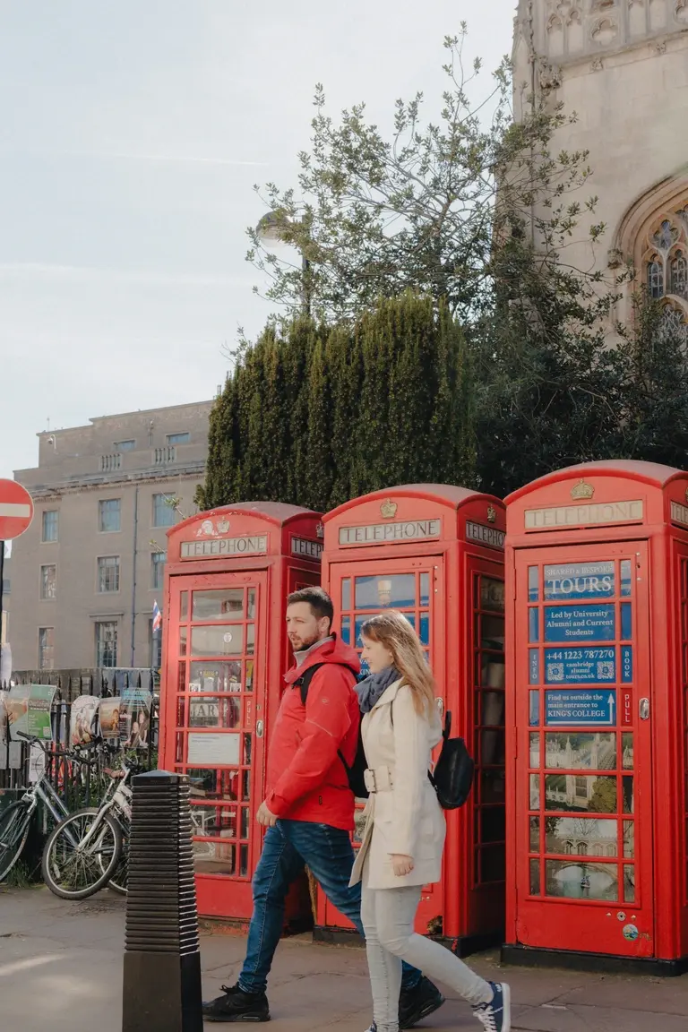 Couple walking past church and telephone boxes with red matching tones