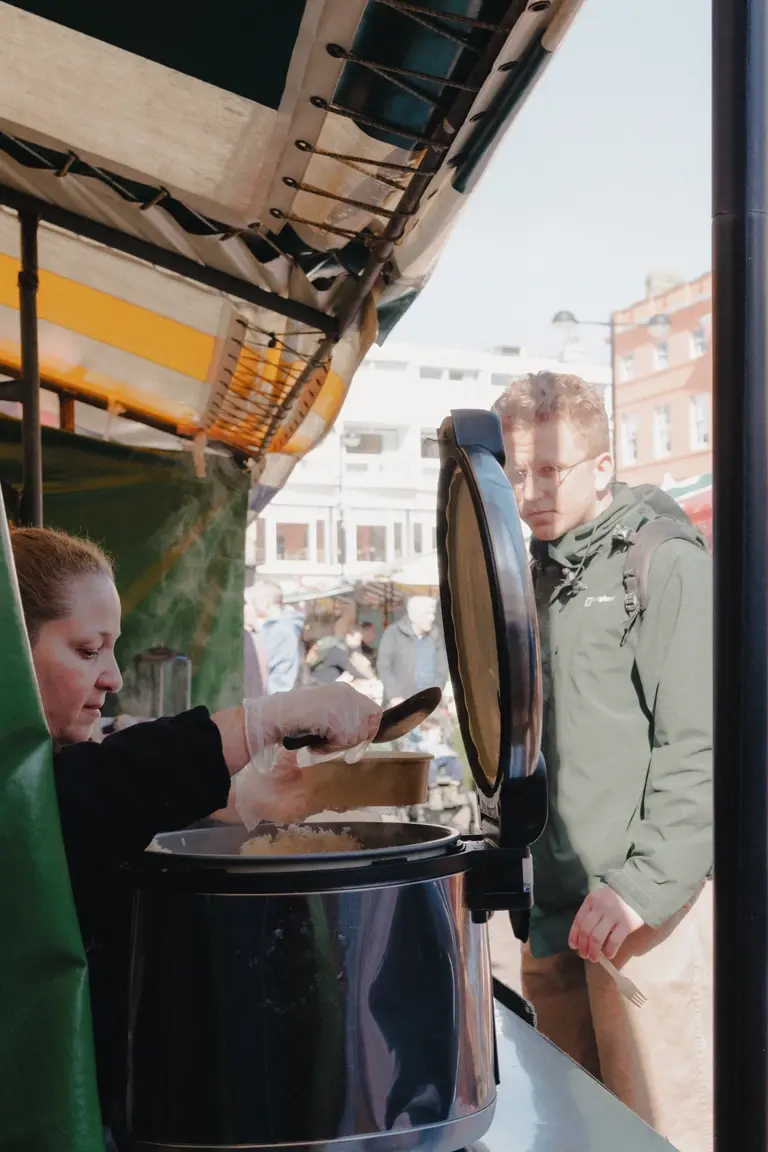 Woman serving rice dish at Cambridge market stall