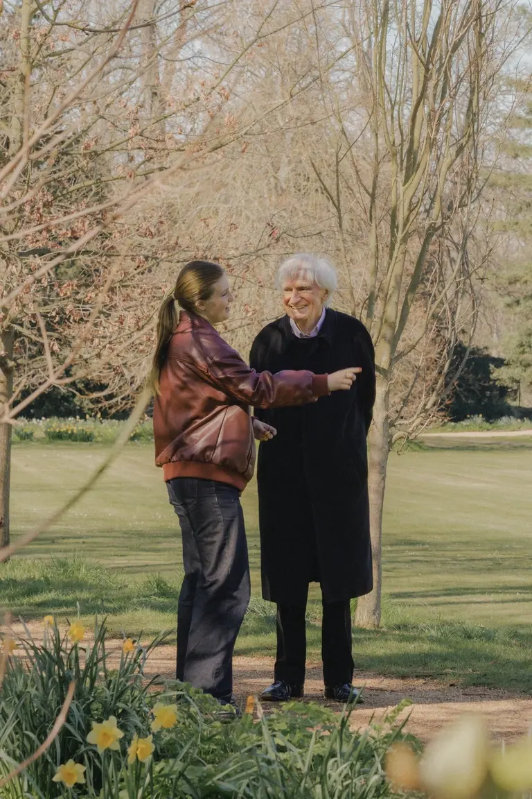 Professor and student having a joyful conversation in St John's College gardens