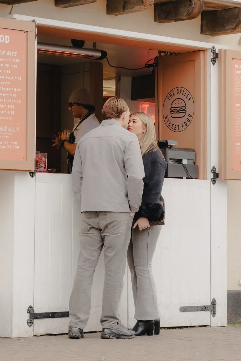 Happy couple sharing a moment in Old Leigh while waiting for food