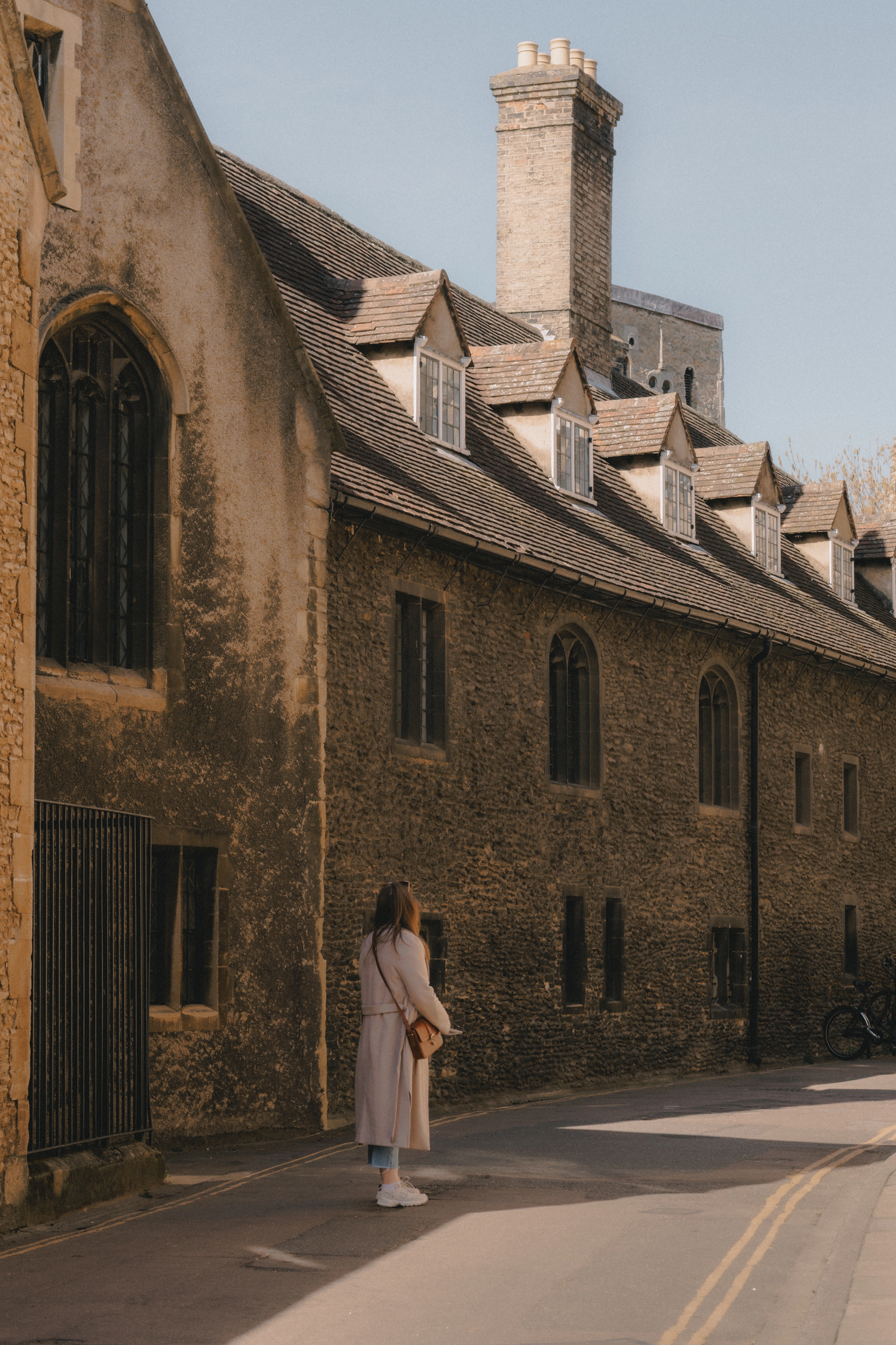 Woman looking at old cambridge building