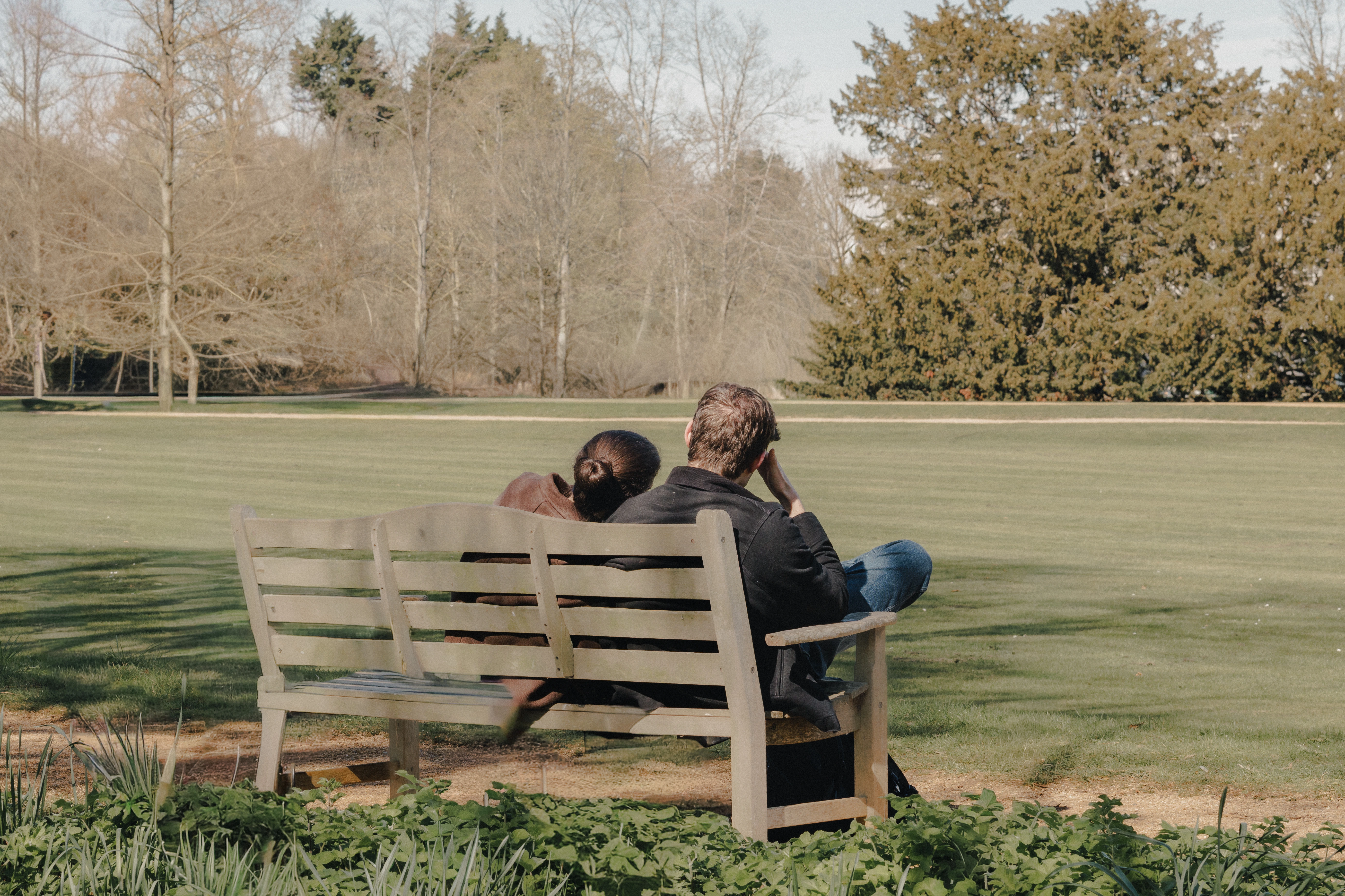 Couple sitting on bench overlooking St. John's College, Cambridge