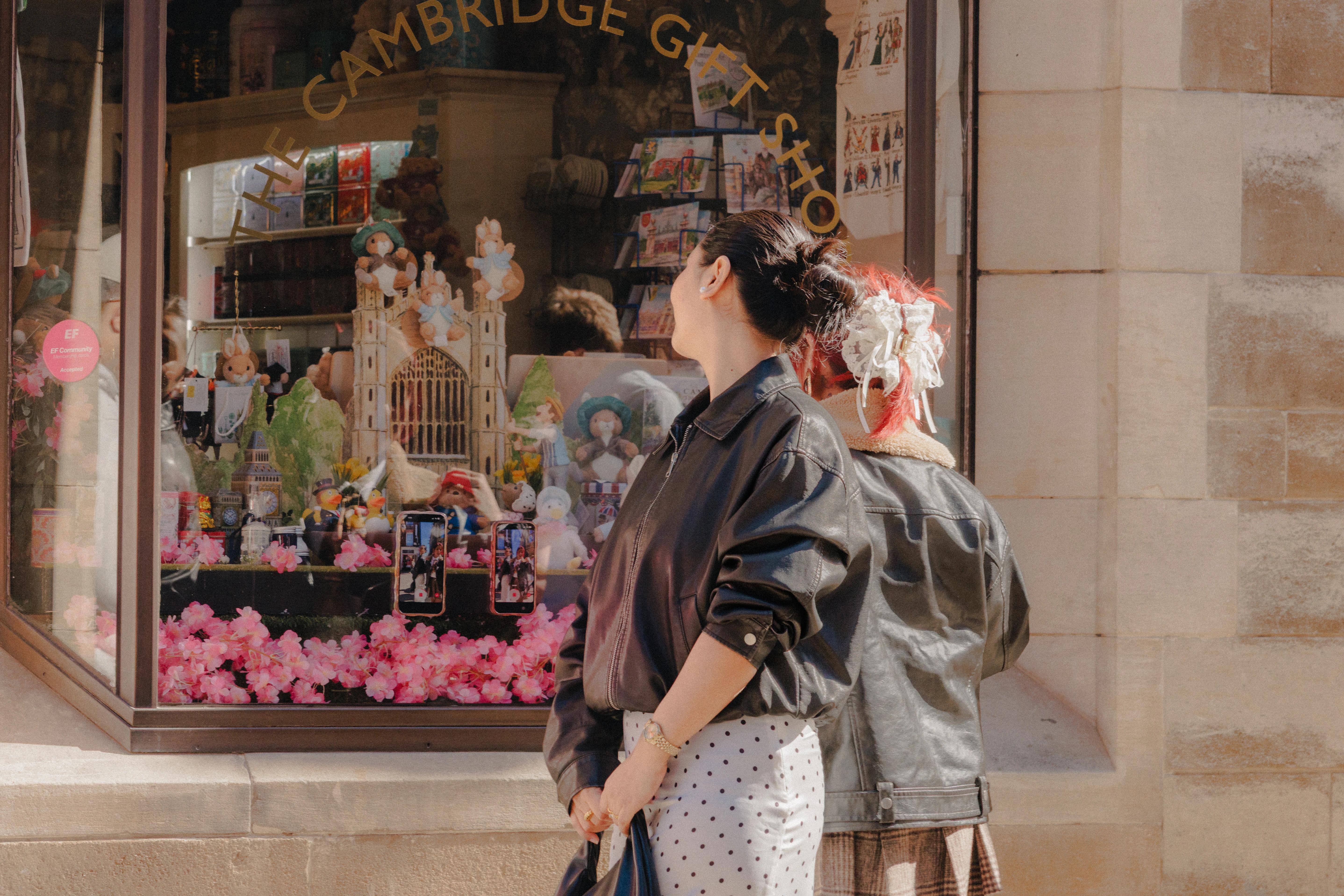 Friends taking playful photos from shop window